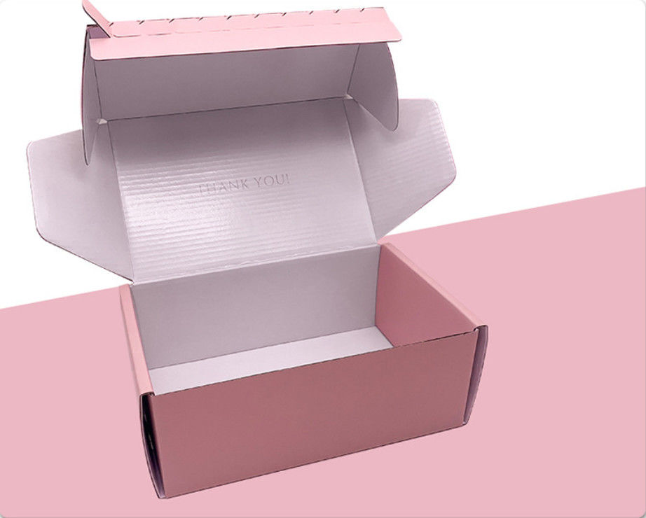 Embalaje de tarjetas rosadas onduladas de ropa Cajas de regalo con cinta adhesiva
