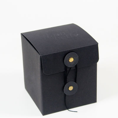 Logotipo en cartón negro en relieve personalizado para velas con mirillas y cintas